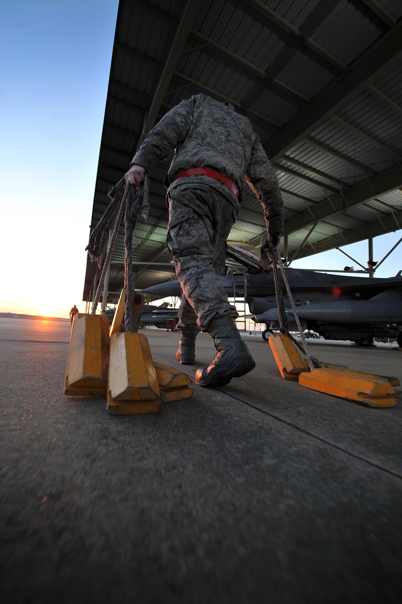 U.S. Air Force Airman 1st Class Chris Headley, 77th Fighter Squadron crew chief, drags several chocks to be put in place at the wheel base of each F-16 Fighting Falcon aircraft at the beginning of an Operational Readiness Exercise, Jan. 31, 2012, Shaw Air Force Base, S.C. The ORE evaluated the 20th Fighter Wing's ability to meet wartime and contingency tasks. During this particular exercise, 77th FS personnel prepped and launched several F-16s to challenge and enhance their wartime capabilities. (U.S. Air Force photo by Senior Airman Kenny Holston/Released)

