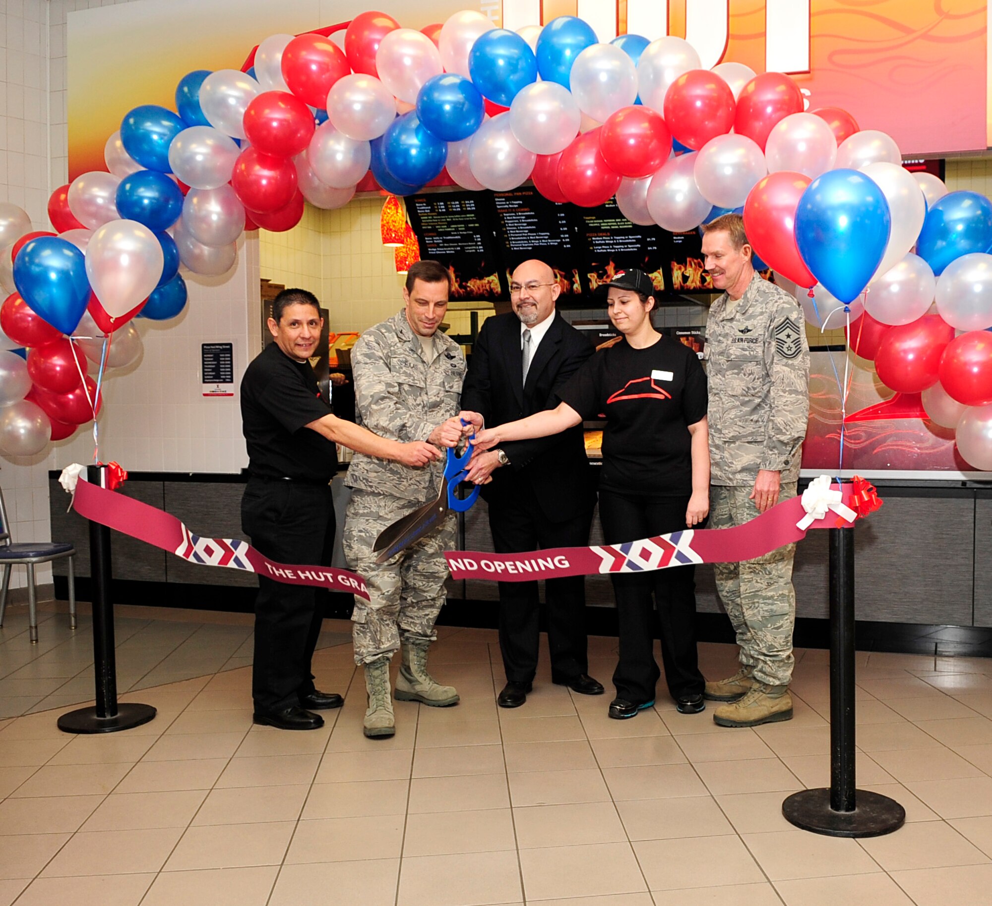 RAF MILDENHALL, England – (from left) Javier Saucedo, food court manager, Col. Christopher Kulas, 100th Air Refueling Wing commander, Lorenzo Salgado, general manager of the UK Consolidated Exchange, Mariana DaSilva, The Hut manager, and Chief Master Sgt. Christopher Powell, 100th ARW command chief, cut the ribbon during the grand opening of The Hut at the Exchange here Feb. 1, 2012. The Exchange offers the base populace multiple eateries in its food court. (U.S. Air Force photo/Senior Airman Ethan Morgan)