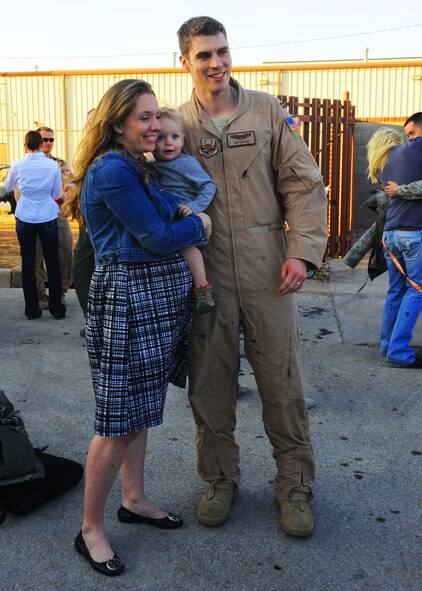Capt. Joshua Capper, 40th Airlift Squadron, poses with his family on Jan. 30, 2012, after returning to Dyess Air Force Base, Texas, after a four month deployment. Capper deployed as a crewmember for the first C-130J model aircraft to be deployed from Dyess. (U.S. Air Force photo by Airman 1st Class Cierra Bullock/ Released) 