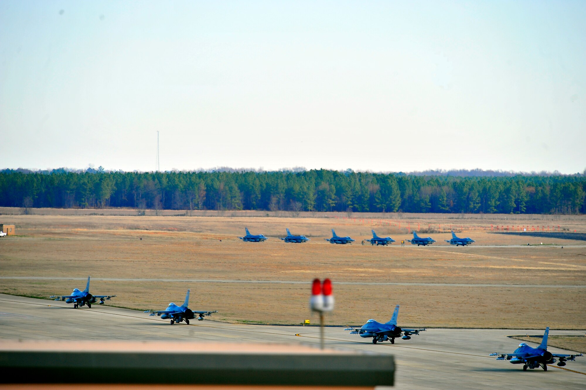 U.S. Air Force F-16 Fighting Falcon jets, taxi down the flightline as other fighter jets line up in formation during an Operational Readiness Exercise at Shaw Air Force Base, S.C. Jan. 31, 2012. ORE’s train Shaw team members to be mission capable and prepare for deployments. (U.S. Air Force photo/Senior Airman Neil D. Warner/Released)