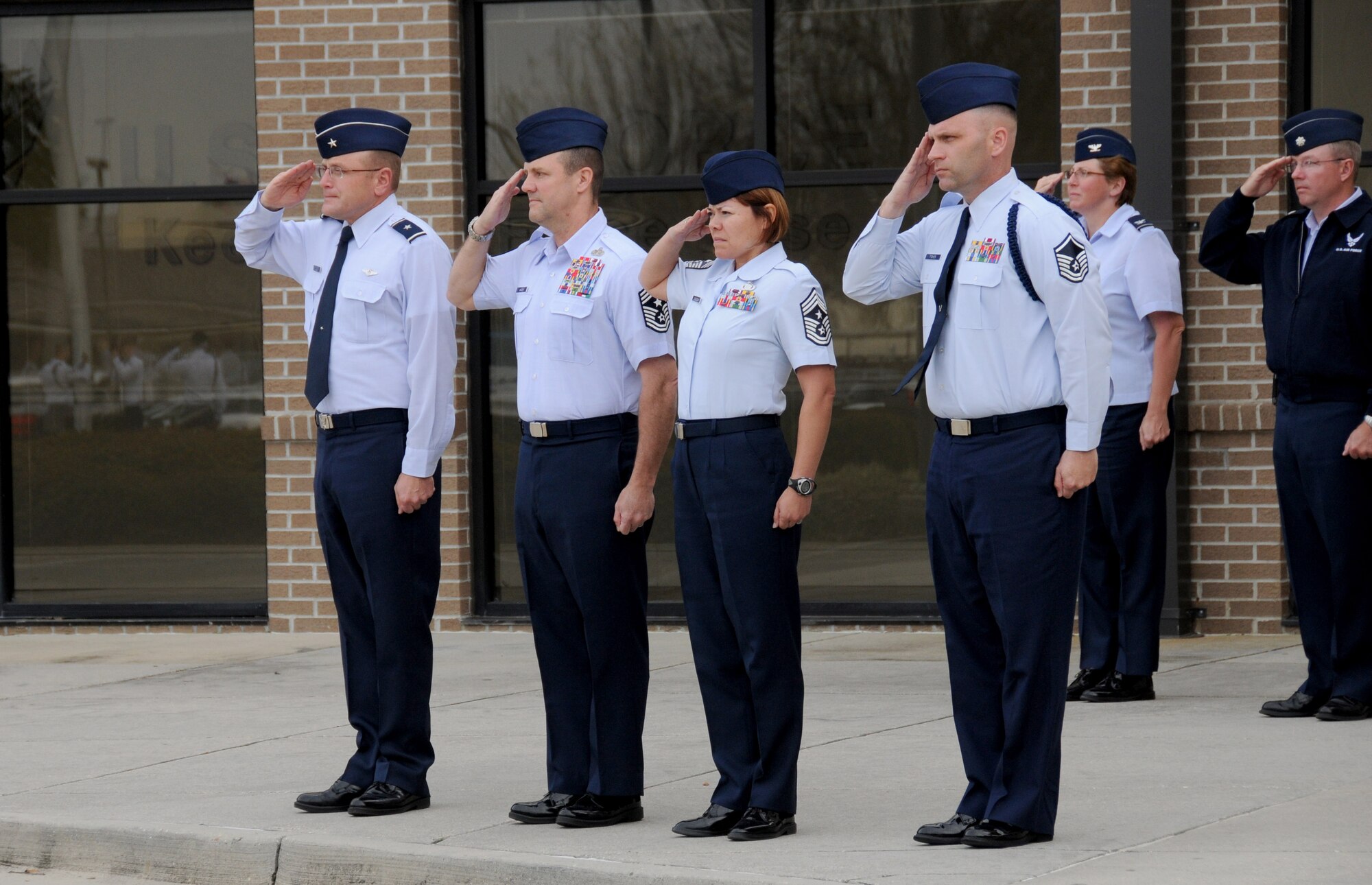 Brig. Gen. Andrew Mueller, 81st Training Wing commander; Chief Master Sgt. Oscar “Deno” Mackin, 2nd Air Force command chief; Chief Master Sgt. Angelica Johnson, 81st TRW command chief; Master Sgt. Anthony Fisher, 81st Training Group military training superintendent; Col. Maureen Smith, 81st TRG commander; and Lt. Col. Scott Solomon, 81st TRG deputy commander, salute during a retreat ceremony Jan. 30, 2012, at the Levitow Training Support Facility, Keesler Air Force Base, Miss.  Keesler is home to 2nd Air Force headquarters and the first of six bases the new command chief is scheduled to tour through June.  (U.S. Air Force photo by Kemberly Groue)