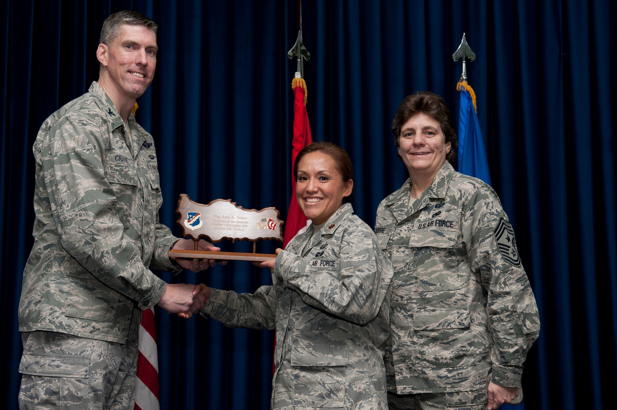 Maj. Kim Arnold, 39th Contracting Squadron commander, accepts the Volunteer of the Quarter Award on behalf of Staff Sgt. Aziz Tetou, 39th CONS, Jan. 31, 2012, at the Club Complex ballroom at Incirlik Air Base, Turkey. (U.S. Air Force photo by Tech. Sgt. Michael B. Keller/Released)