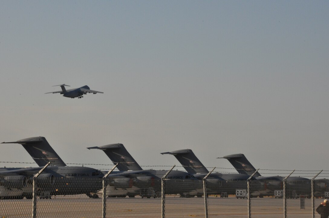 WRIGHT-PATTERSON AIR FORCE BASE, Ohio - The final 445th Airlift Wing C-5 Galaxy flies over the wing’s newest asset, the C-17 Globemaster III, after departing Wright-Patterson Air Force Base Jan. 31, 2012, on its final flight to the 309th Aerospace Maintenance and Regeneration Group, also known as the “Boneyard” at Davis-Monthan Air Force Base, Tucson, Ariz. (U.S. Air Force photo/Stacy Vaughn)