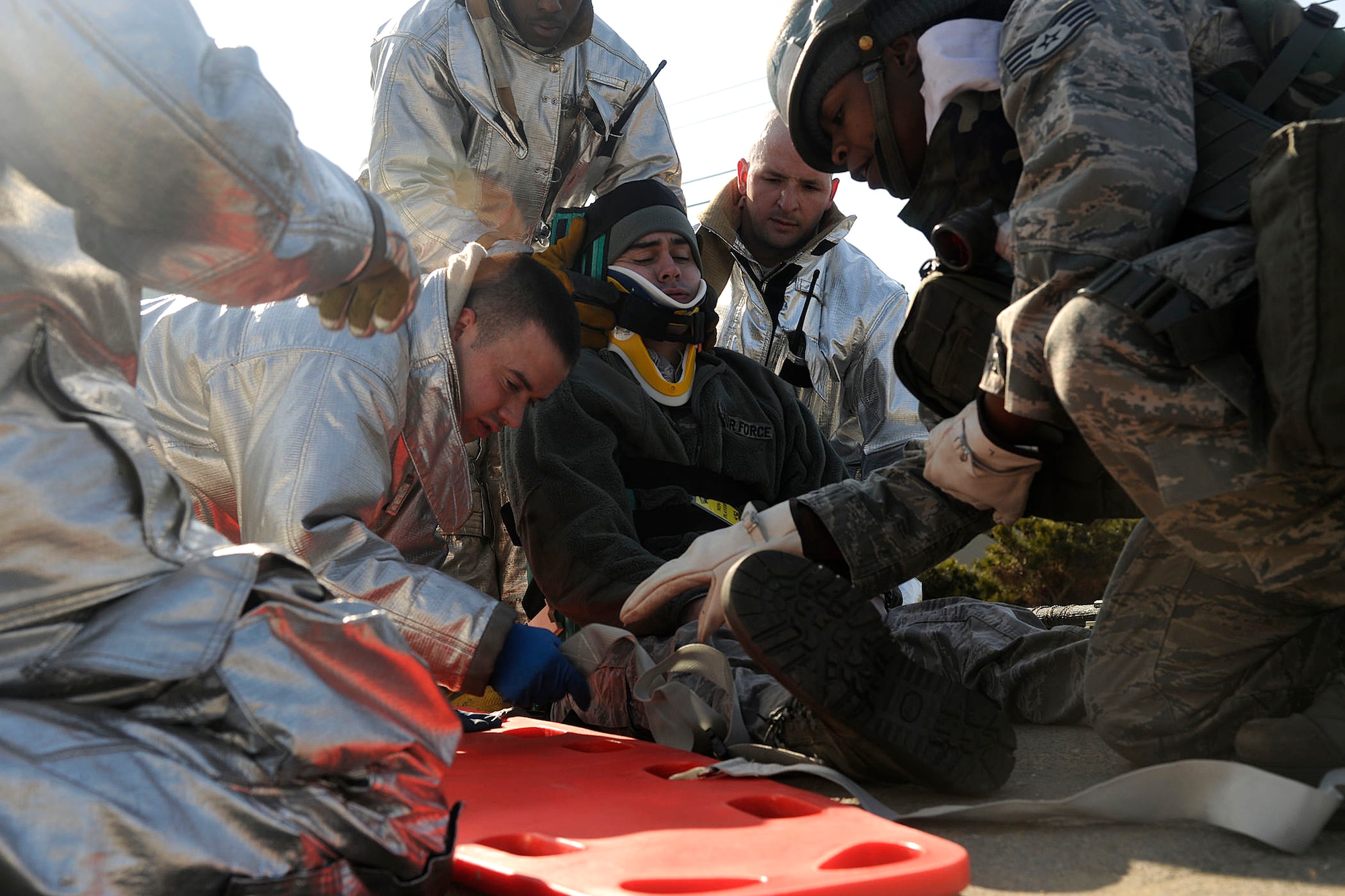 Firefighters from the 8th Civil Engineer Squadron provide aid to a role player of a simulated car crash during exercise Beverly Bulldog 12-01 at Kunsan Air Base, Republic of Korea Jan. 30, 2012. It's the first Peninsula Operational Readiness Exercise of the year to test the Wolf Pack's ability to execute combat operations, receive follow-on forces, defend the base, and take the fight north. (U.S. Air Force photo by Staff Sgt. Rasheen Douglas/Released)