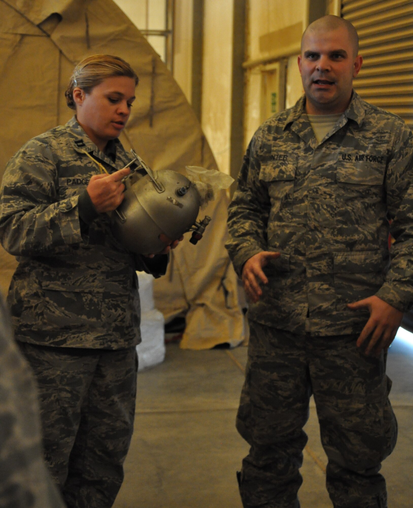 Capt. Nicole Padgett, 332nd Air Expeditionary Wing Sexual Assault Response Coordinator, gets a close-up view of a Halon container while Tech. Sgt. James Winter, 332nd Maintenance Squadron, explains how it is used Jan. 31, 2012 at an undisclosed location in Southwest Asia. Halon is a fire suppressant used by F-16 pilots. Padgett is deployed from Ramstein Air Base, Germany and is a native of Green River, Wyo. Winter is deployed from Shaw Air Force Base, S.C. (photo by Senior Airman Melanie Holochwost)