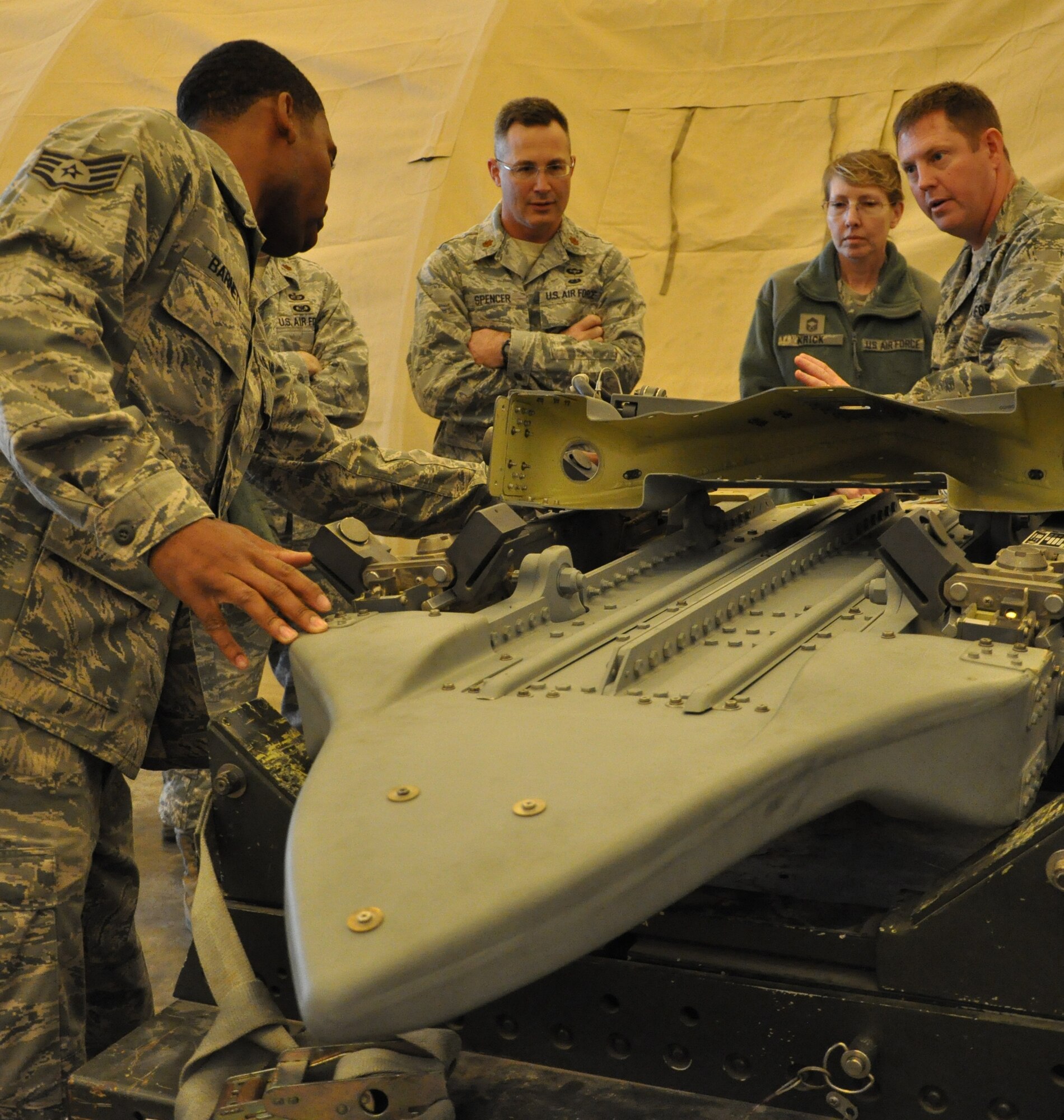 Staff Sgt. David Barnett, 332nd Expeditionary Maintenance Squadron, explains how weapons are connected to F-16s during a maintenance tour Jan. 31, 2012 at an undisclosed location in Southwest Asia. During the two-hour tour, maintenance personnel taught wing staff agency members about different aspects of their jobs including phase, weapons, sheet metal, egress and more. Barnett is deployed from Shaw Air Force Base, S.C., and is a native of Stone Mountain, Ga. (photo by Senior Airman Melanie Holochwost)