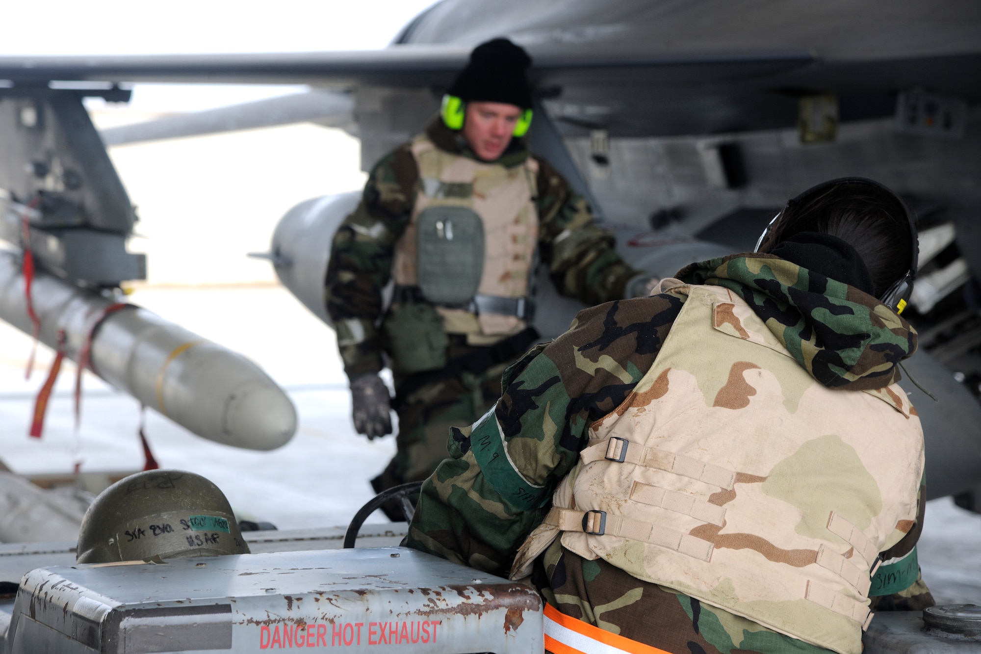Senior Airman Eva Stockslager and Staff Sgt. Jared Carroll, 20th Expeditionary Aircraft Maintenance Squadron weapons load crew members, work together to position an air-to-ground missile (AGM - 88) for loading onto an F-16 Fighting Falcon during a Peninsula Operational Readiness Exercise at Kunsan Air Base, Republic of Korea Jan 31, 2012. PENOREs ensure Wolf Pack Airmen are capable of performing their duties in wartime conditions. Both Airmen are deployed from Shaw Air Force Base, S.C. (U.S. Air Force photo by Staff Sgt. Rasheen A. Douglas/Released)