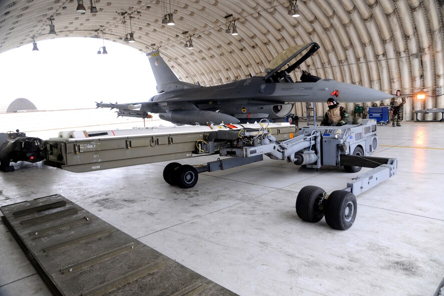 Senior Airman Eva Stockslager, 20th Expeditionary Aircraft Maintenance Squadron weapons load crew member, uses an MHU bomb lift truck to transport two air-to-ground missiles (AGM - 88) for loading onto an F-16 Fighting Falcon during a Peninsula Operational Readiness Exercise at Kunsan Air Base, Republic of Korea Jan 31, 2012. PENOREs ensure Wolf Pack Airmen are capable of performing their duties in wartime conditions. Stockslager is deployed from Shaw Air Force Base, S.C., as part of an additional Theater Security Package that supplements air power on the peninsula. (U.S. Air Force photo by Staff Sgt. Rasheen A. Douglas/Released)