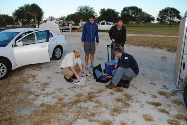 LAKE OKEECHOBEE, Fla. — Damon Wolfe (lower right), geodesist with the U.S. Army Corps of Engineers Jacksonville District, leads pre-operation checks on the NOVA Unmanned Aerial Vehicle (UAV) in advance of a flight here, Nov. 29, 2011, with help from Victor Wilhelm, Brandon Evers, and Mike Hensch. The NOVA was flown multiple times to take pictures from above the lake that will help USACE biologists track various plant species.