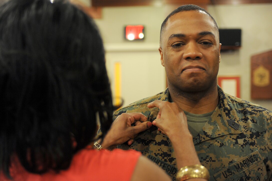 Frances Whiteside pins her husband, Allen Whiteside, 39, to the rank of master gunnery sergeant in the United States Marine Corps at Marine Barracks Washington Feb. 1. The rank of master gunnery sergeant is the highest enlisted rank achievable in the Marine Corps, along with the equivalent rank of sergeant major.