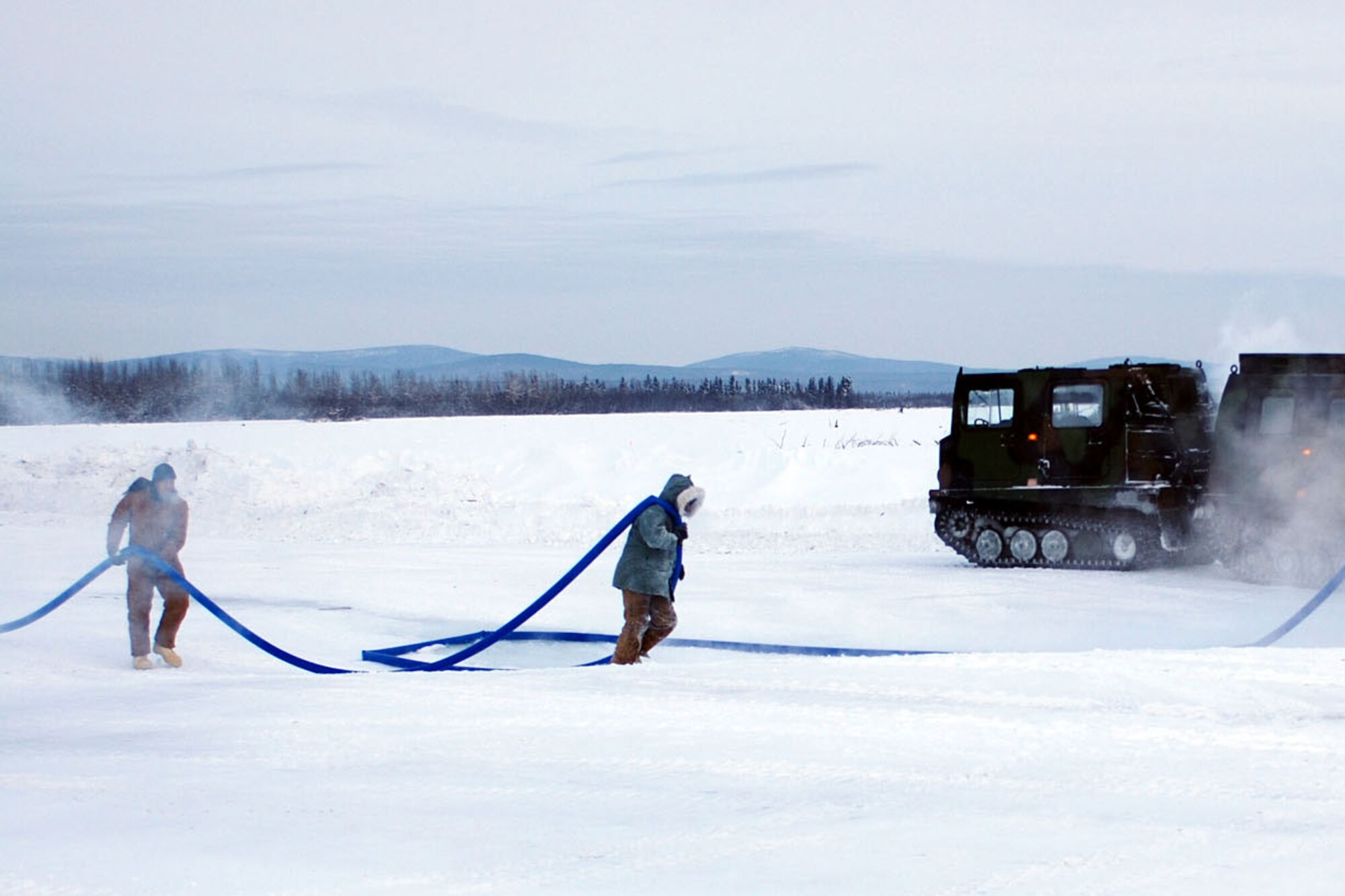 Soldiers from the 56th Engineer Company spread water to thicken a path of the Tanana River’s frozen surface during an ice-bridge construction project Jan. 25. (U.S. Army photo/Staff Sgt. Matthew E. Winstead)