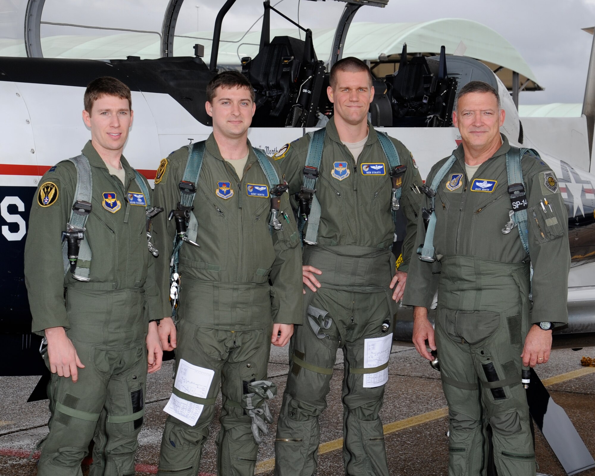 Capt. Adam Schubert, 1st Lt. Kent North and Capt. Benjamin Staats, instructor pilots in the 41st Flying Training Squadron, pause with Gen. Gary North, Pacific Air Forces commander, for a photo in front of a T-6 Texan Jan. 26 at Columbus Air Force Base, Ohio. Gen. North flew a formation sortie in the T-6 with his son, 1st Lt. North during his visit to Columbus. (U.S. Air Force photo/Elizabeth Owens)