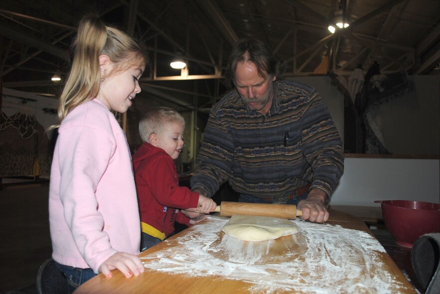 Mykennah Biermann, 4, and her brother Gabriel, 2, help Scott Woodland roll dough to make breadsticks during a Dutch oven cooking class at Outdoor Recreation Jan. 25. The classes are held every quarter and are taught by Montana IDOS president Robert Dowdy, 341st Maintenance Operations Squadron library technician. (U.S. Air Force photo/Airman 1st Class Katrina Heikkinen)