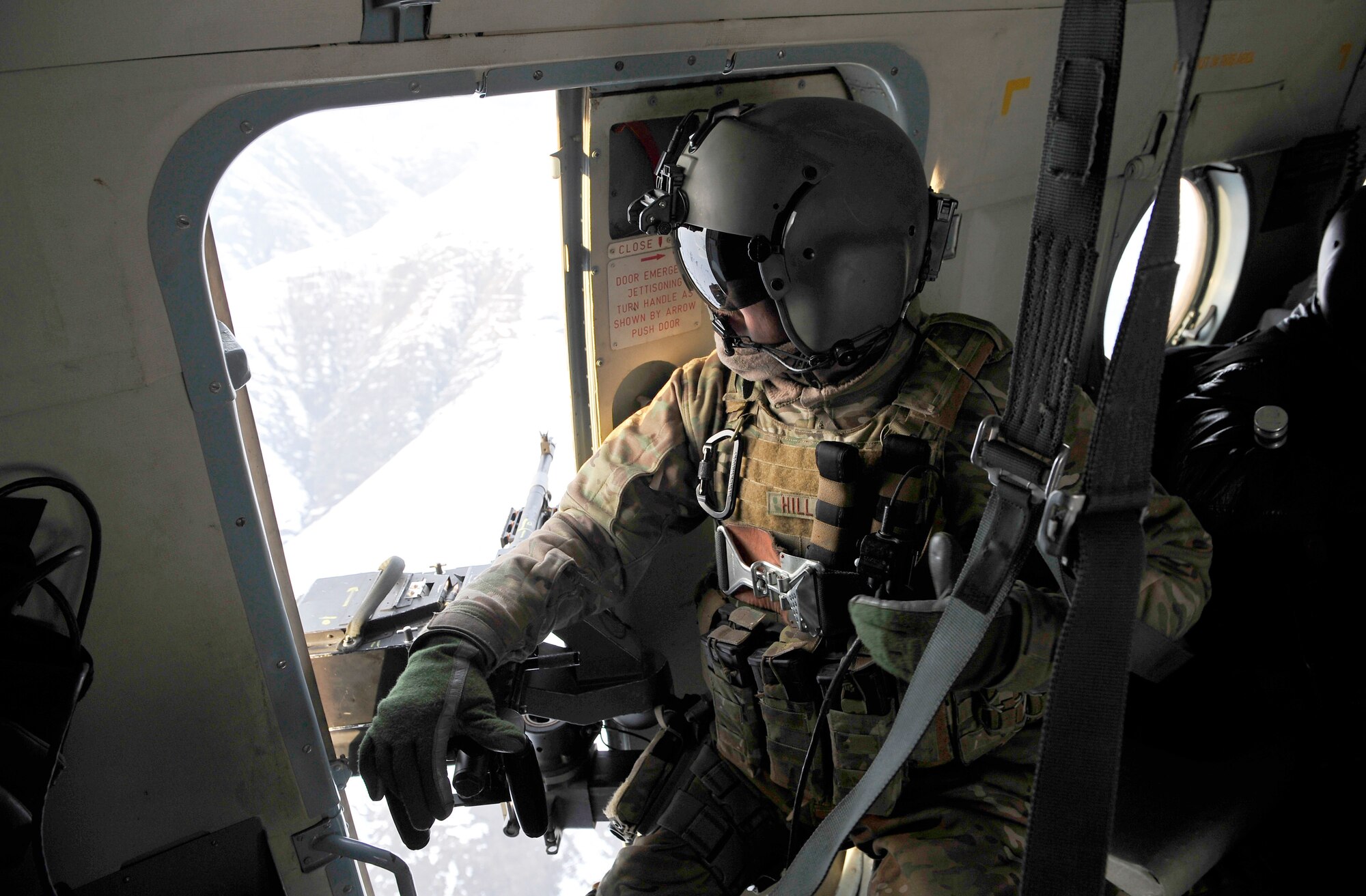 Staff Sgt. Jonathan Hill, an Mi-17 helicopter engineer from the 438th Air Expeditionary Advisory Squadron, who is deployed from the 36th Rescue Flight at Fairchild, scans the ground from his helicopter as it flies a rescue mission Jan. 24. (U.S. Air Force photos by Master Sgt. Shane A. Cuomo)