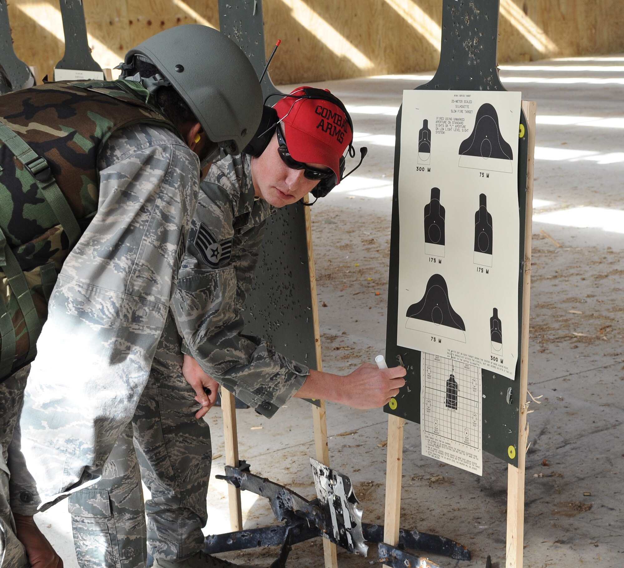 U.S. Air Force Staff Sgt. Mitchell House, 23rd Security Forces Squadron Combat Arms Training and Maintenance instructor, marks where students should aim when shooting an M4 assault rifle during a CATM class at Moody Air Force Base, Ga., Feb. 1, 2012. CATM instructors allow students to shoot practice rounds before the actual qualification round. (U.S Air Force photo by Airman 1st Class Olivia Dominique/Released)