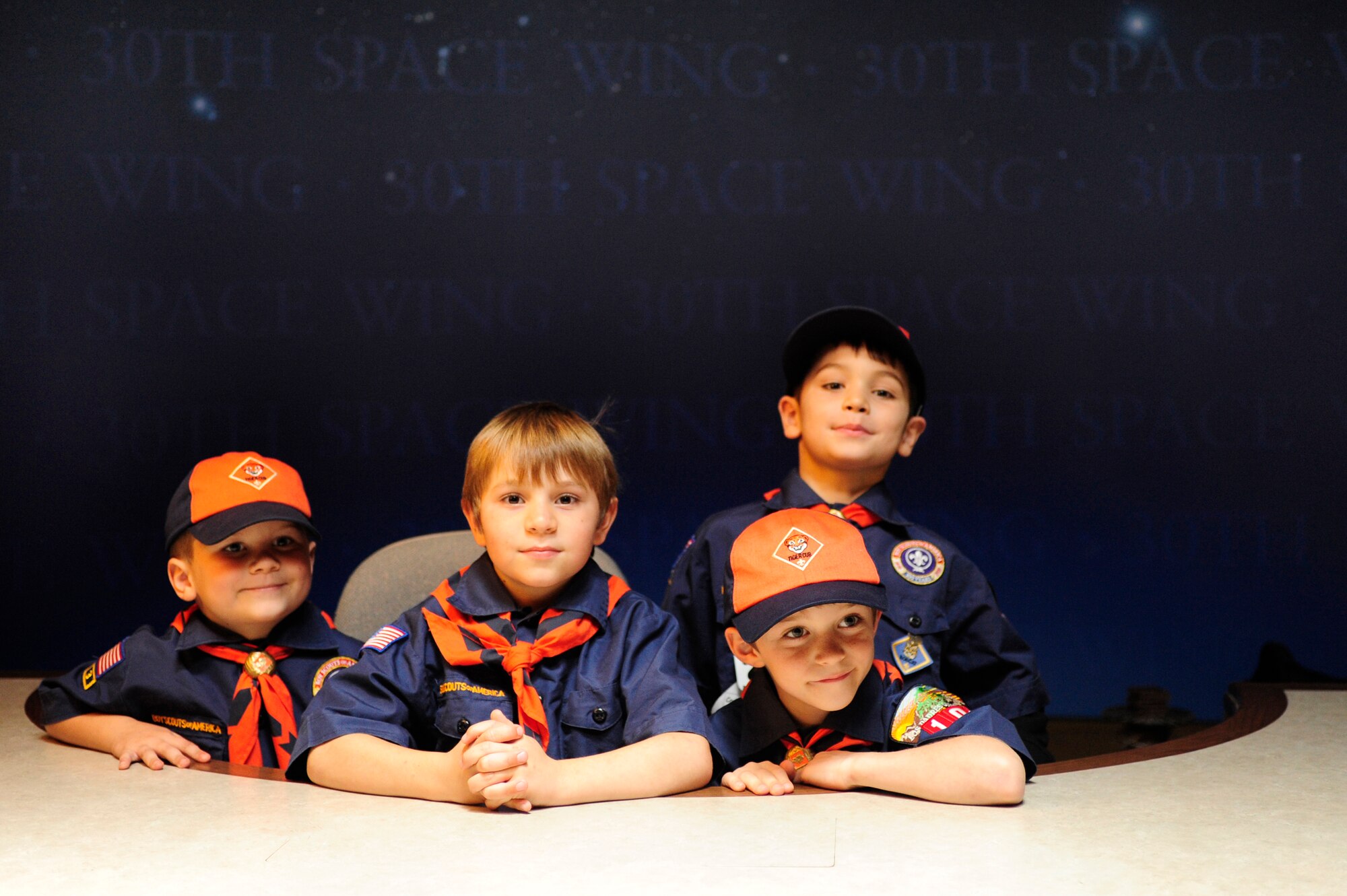 VANDENBERG AIR FORCE BASE, Calif. -- Vandenberg Cub Scout Pack 102 poses for a photo on the news anchor table during their visit to the 30th Space Wing Public Affairs Office here Wednesday, Feb. 1, 2012. The PA staff helped the scouts earn their news and media merit badges. (U.S. Air Force photo/Staff Sgt. Andrew Satran) 