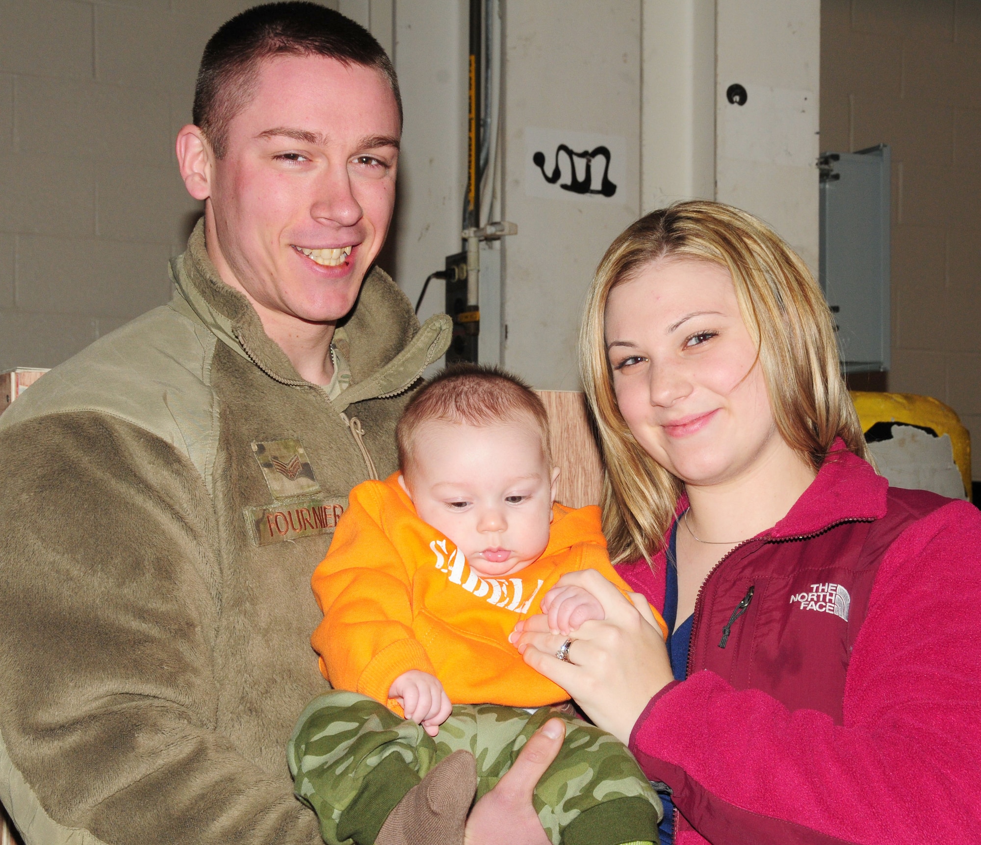 Senior Airman Daniel Fournier, 103rd Security Forces Squadron, greets his son, Hunter, and wife, Angela upon his return home from Afghanistan at Bradley Air National Guard Base, East Granby, Conn., Jan. 30, 2012. Hunter was born during Fournier's six-month deployment to Bagram Airfield where he performed security and patrol operations. (U.S. Air Force photo by Tech. Sgt. Erin McNamara\RELEASED)