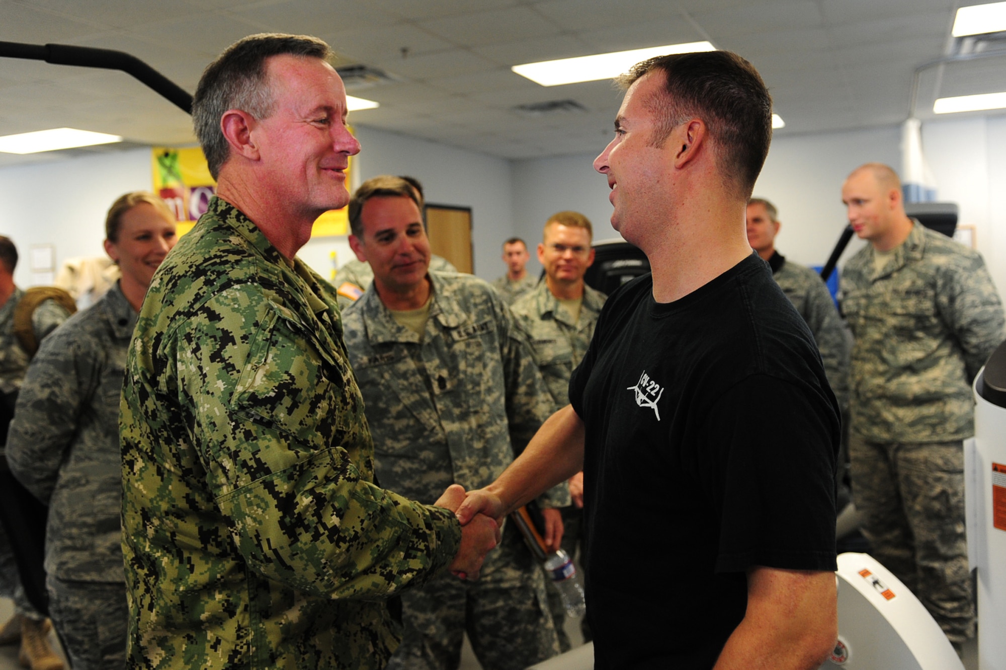 U.S. Navy Adm. William McRaven, commander of U.S. Special Operations Command, reconnects with Staff Sgt. Christopher Curtis, CV-22 flight engineer of the 8th Special Operations Squadron, at 1st Special Operations Medical Group physical and occupational therapy clinic Jan. 30, 2012, on Hurlburt Field, Fla. The admiral was present for Curtis' emergency surgery down range after an aircraft mishap. (U.S. Air Force photo/Senior Airman Eboni Reams)


