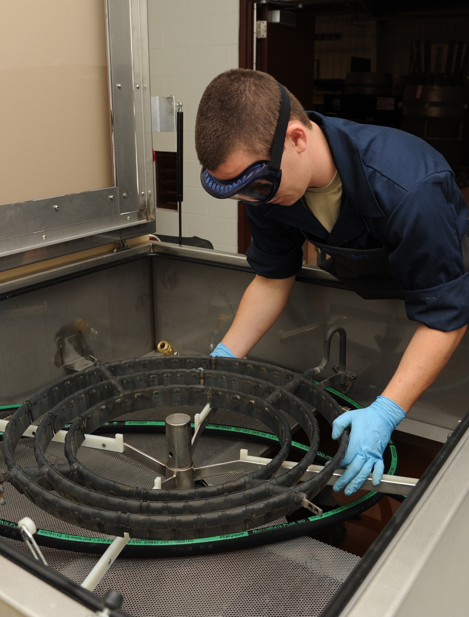 U.S. Air Force Airman 1st Class Josh McCall places a spray ring inside a tester on Seymour Johnson Air Force Base, N.C., Jan. 30, 2012. A spray ring supplies fuel to the engine when an aircraft needs a rapid thrust. The tester ensures build-up is removed and the spray ring functions properly. McCall is a 4th Component Maintenance Squadron module repair technician from Flomaton, Ala. (U.S. Air Force photo/Senior Airman Whitney Stanfield/Released)