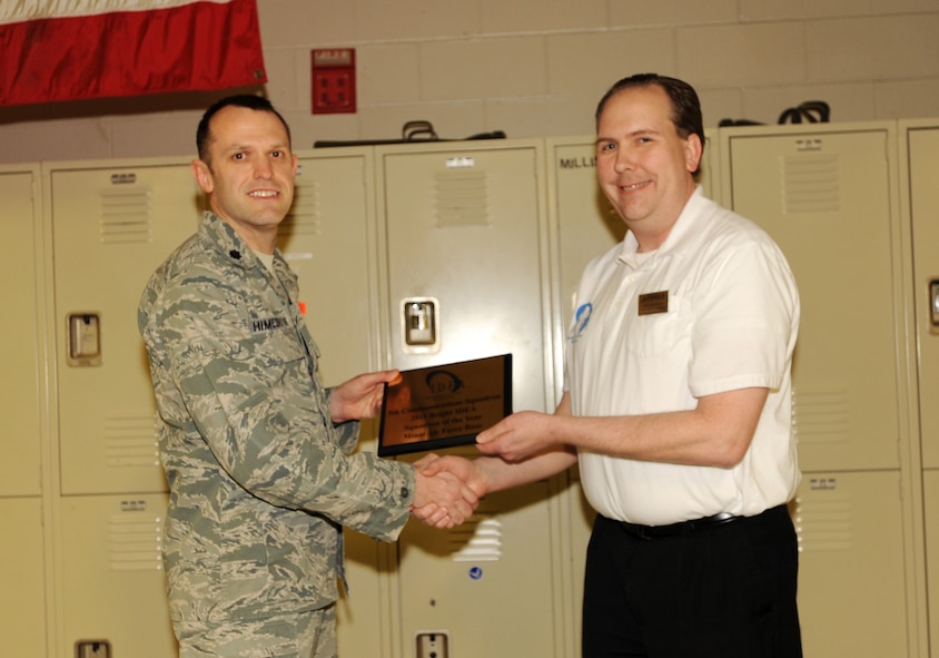 MINOT AIR FORCE, N.D. -- Lt. Col. Les Himebrook, 5th Communications Squadron commander, is presented with the Bright IDEA Squadron of the Year Award by Charles Hamilton, 5th Force Support Squadron IDEA program manager, during their squadron commander's call here Jan. 27. The 5th CS was recognized for having submitted the most ideas during a base-wide competition among squadrons to see who could provide input in job ingenuity. In 2011, ideas from Team Minot Airmen saved the base $1.8 million and two individuals were awarded the max financial award of $10,000 for their ideas. (U.S. Air Force photo/Senior Airman Jose L. Hernandez)

