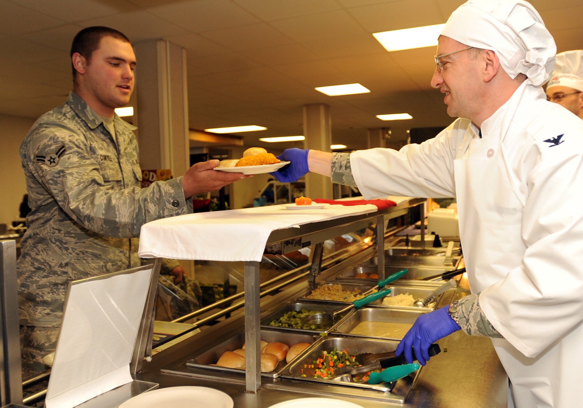 MINOT AIR FORCE BASE, N.D. -- Col. Max Mitchell, 5th Bomb Wing vice commander, serves a dinner plate to Airman 1st Class Jordan Coryell, 5th Maintenance Squadron electrical and environmental systems apprentice, during a quarterly Airman Appreciation Meal at the Dakota Inn Jan. 26. Base leadership, squadron commanders and first sergeants express support for the Airmen here by helping to serve unique dishes for an afternoon at the Dakota Inn. (U.S. Air Force photo/Senior Airman Jose L. Hernandez)