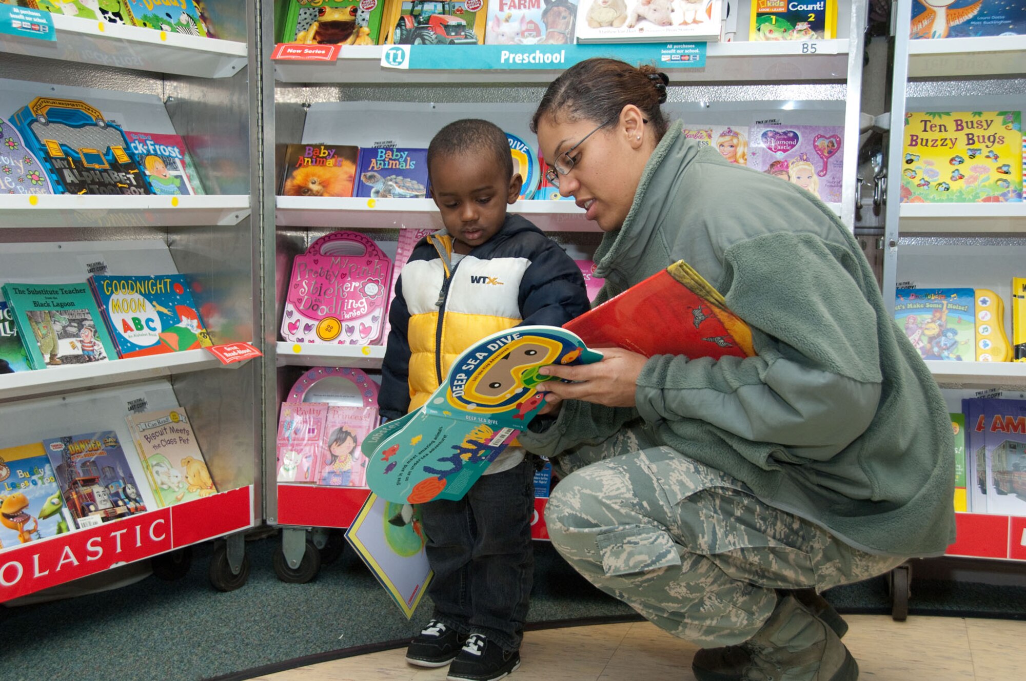 HANSCOM AIR FORCE BASE, Mass. – Staff Sgt. Chrystle McGee and her son, Anthoney, select books to purchase at the book fair held at the Child Development Center Jan. 31. Money raised will allow the CDC to purchase additional books for their classrooms. (U.S. Air Force photo by Mark Herlihy)