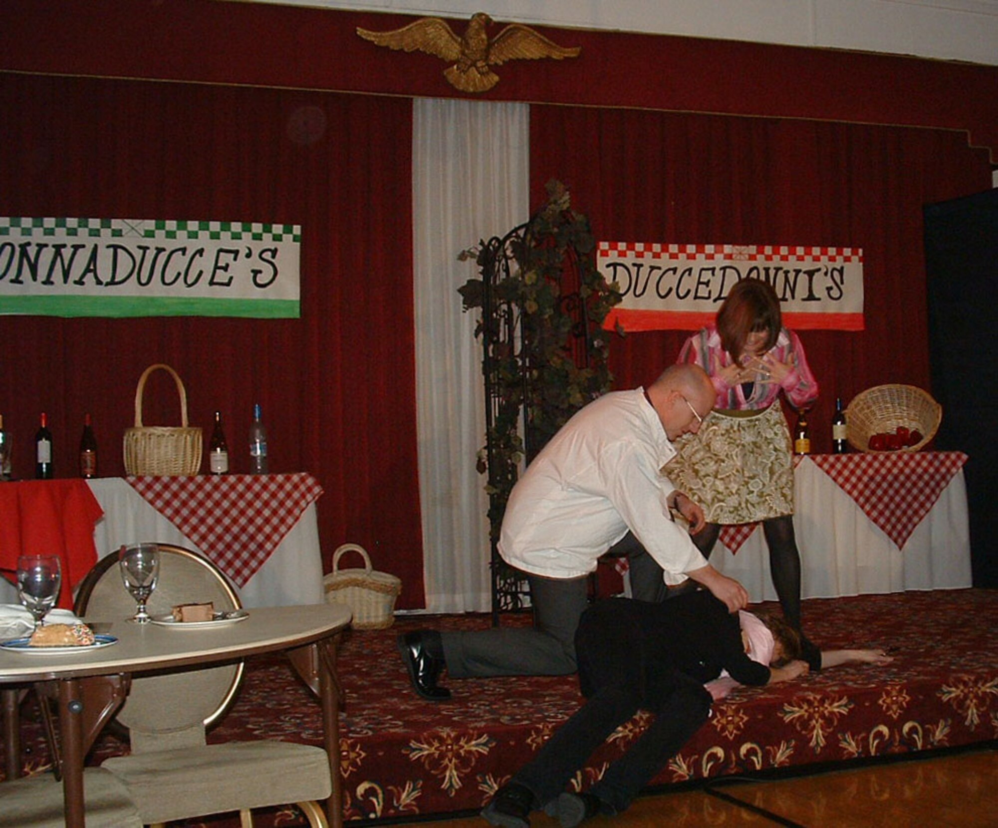 HANSCOM AIR FORCE BASE, Mass. - Donnaducce Chef Nino and Duccedonni Chef Nina (Col. Bill Leister and Deb Leister) find Maria (Cynthia DeLaPena) “dead” in front of the restaurants during Death by Dessert at the Minuteman Commons Jan. 28. The Hanscom Spouses Club hosted the murder mystery dinner theater, which allowed the audience to guess the culprit. (Courtesy photo)