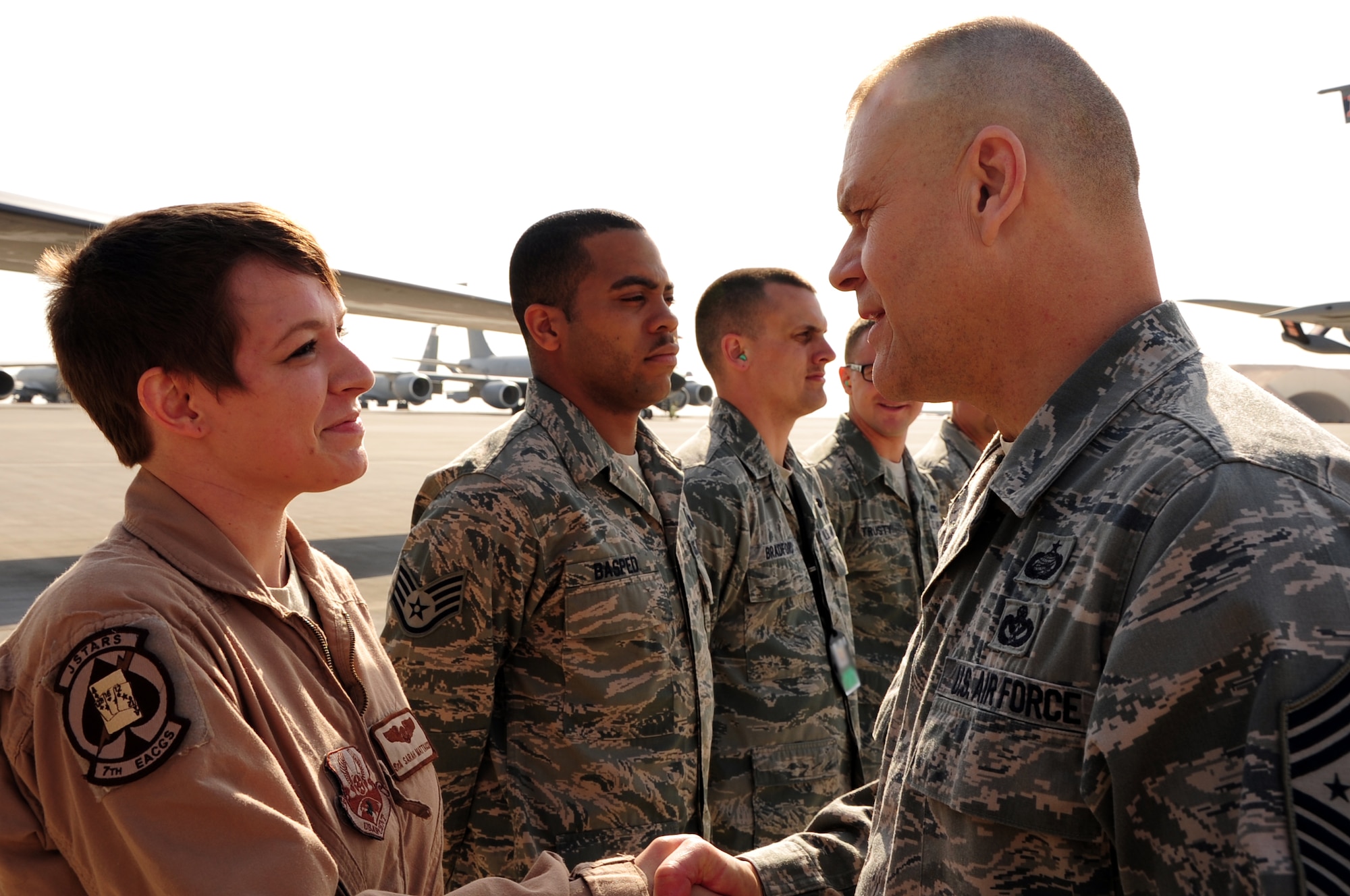 SOUTHWEST ASIA -- Chief Master Sgt. of the Air Force James Roy presents Senior Airman Sarah Mattausch, 7th Expeditionary Air Command and Control Squadron airborne mission system specialist, with a coin during a base visit here Jan. 31, 2012. Mattausch, deployed from Robins Air Force Base, Ga., was recognized for applying key suicide prevention techniques that saved the life of a fellow Airman. During his trip, Roy held an enlisted all-call and visited several units to discuss quality of life issues, resiliency programs and the future of the Air Force. (U.S. Air Force photo/Senior Airman Michael Charles) 
