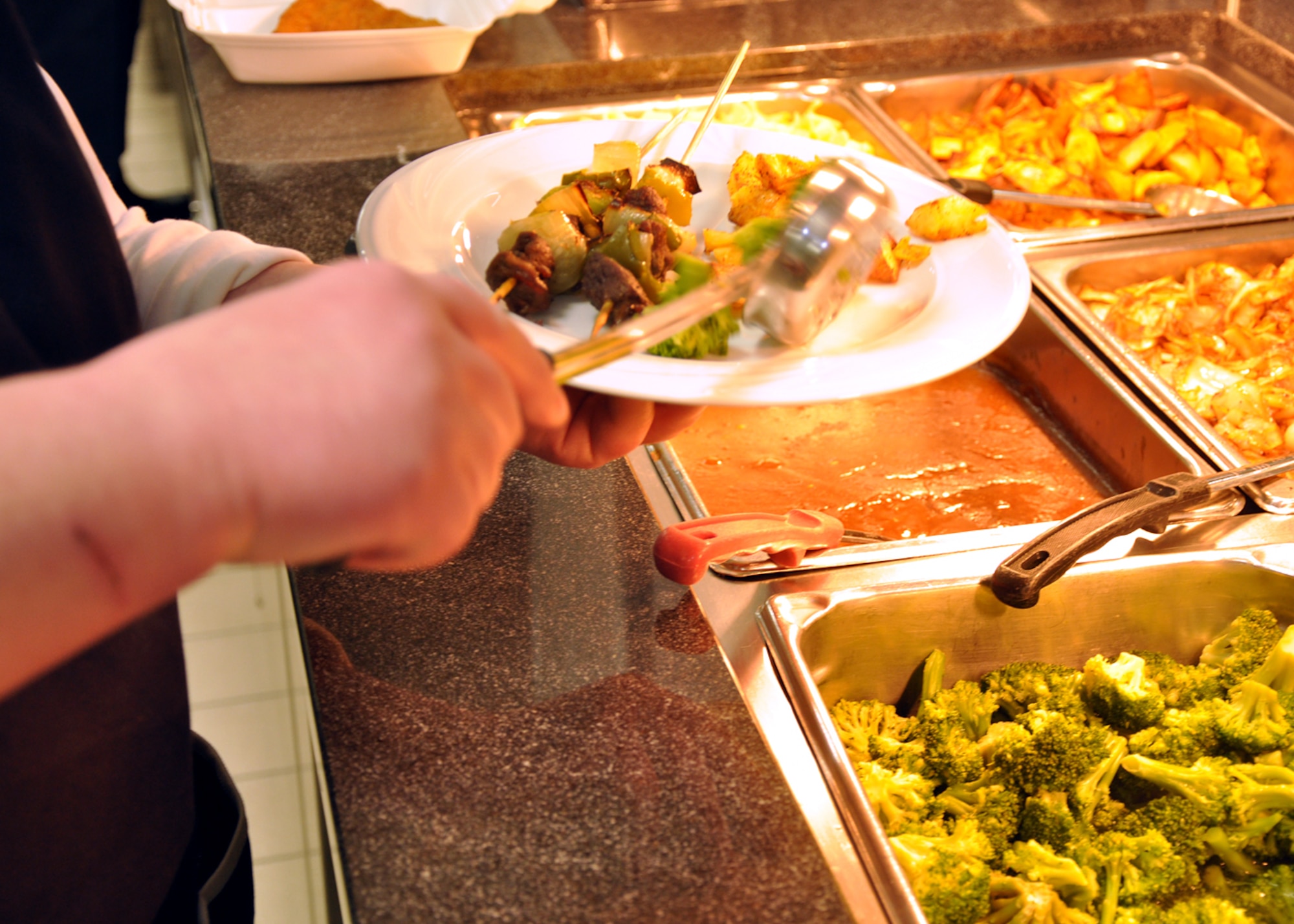 SPANGDAHLEM AIR BASE, Germany – A staff member places a serving of broccoli on a customer’s plate at the Mosel Dining Facility here after the facility’s re-opening ceremony Feb. 1. The building closed in August 2010 for renovations to the cold-storage space, and base engineers used the facility’s closure time to upgrade the serving line, foot-traffic pattern and seating area. The new appearance is designed to make meal times more efficient for DFAC customers. (U.S. Air Force photo/Staff Sgt. Daryl Knee)