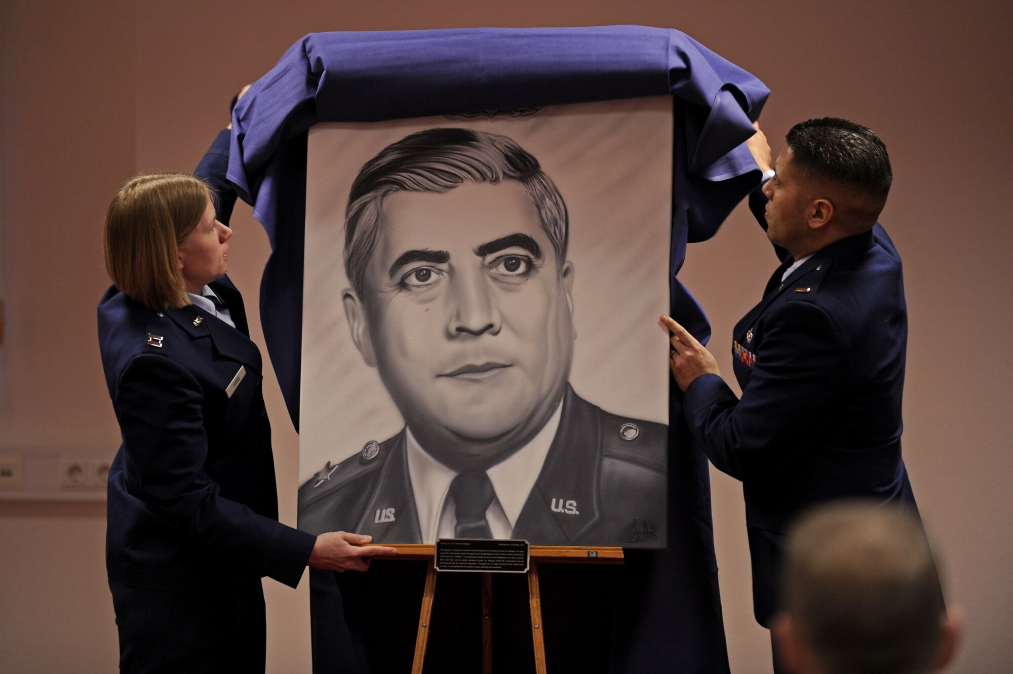 SPANGDAHLEM AIR BASE, Germany – Capt. Kristen Torma, 480th Aircraft Maintenance Unit officer in charge, left, and 2nd Lt. Jeffrey Rodriguez, 81st Aircraft Maintenance Unit assistant officer in charge, unveil a painting at a dedication ceremony in honor of Lt. Gen. Leo Marquez at the Eifel Community Center here Jan. 31. Rodriguez painted the artwork, and it will be displayed at the 52nd Maintenance Group headquarters. Airmen attended the event to honor the achievements and contributions Marquez made to the Air Force in his 33 years of service. Some of Marquez’ additions include the implementation of the Air Force Combat Ammunitions Center — an advanced training course for munitions Airmen — and the maintenance badge that all Air Force maintainers now wear. Marquez died Dec. 30, 2011, at age 79.  (U.S. Air Force photo/Airman 1st Class Matthew B. Fredericks)