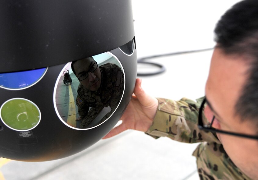 CAMP BASTION, Afghanistan -- Master Sgt. Rogelio Martinez, 76th Expeditionary Rescue Squadron flight engineer, inspects a camera on the front of a HC-130P King. Martinez is responsible for preflight, in-flight and post-flight checks of the aircraft. The flight engineer plays a vital role in the only fixed wing medical evacuation missions flown for Operation ENDURING FREEDOM.  (U.S. Air Force photo/Tech. Sgt. Beth Del Vecchio)