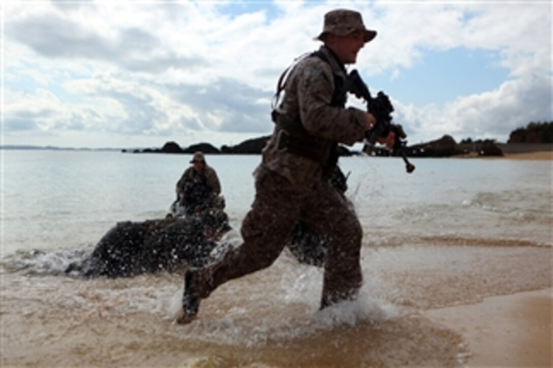 Scout swimmers with Company A, Battalion Landing Team 1st Battalion, 4th Marines, 31st Marine Expeditionary Unit, push onto the beach at Okinawa, Japan, on Jan. 29, 2012.  The Marines are conducting a small boat raid during the Expeditionary Unitís Amphibious Integration Training in preparation for Exercise Cobra Gold 2012.  