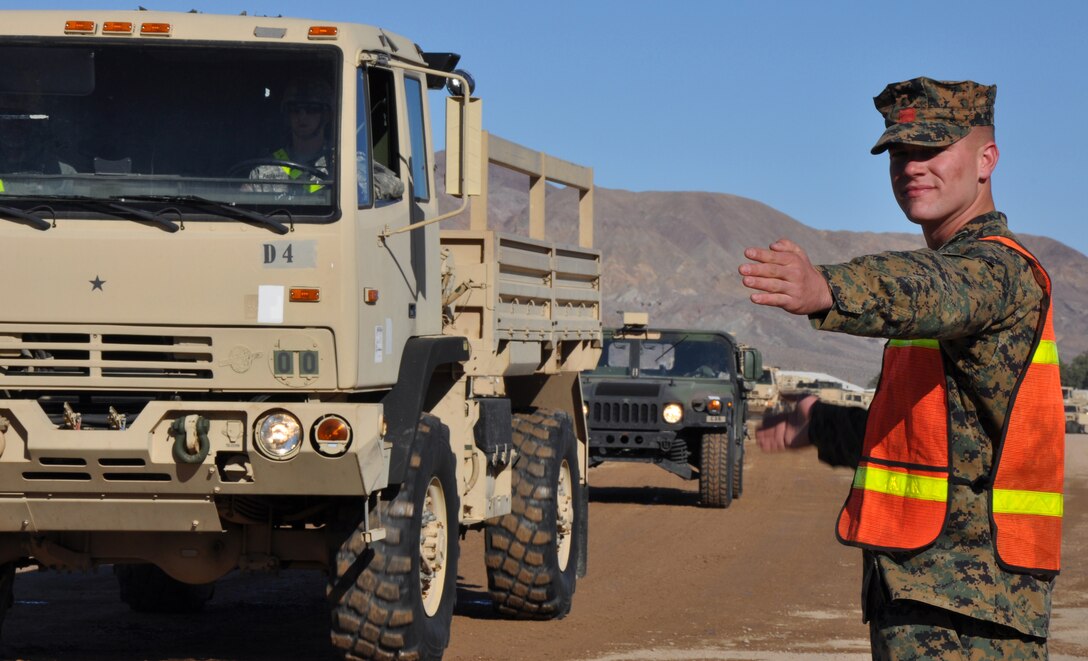 Lance Corporal Kellby Gietl, a landing support specialist with Landing Spport Company, Combat Logistics Regiment 17, 1st Marine Logistics Group waves on traffic during a training exercise held  Feb. 2 aboard Marine Corp Logistics Base Barstow's Yermo annex. While at MCLB Barstow, Gietl, a Springfield Ill. native, conducted traffic control and checked vehicles exiting the base to ensure they were included on the manifest for the event.