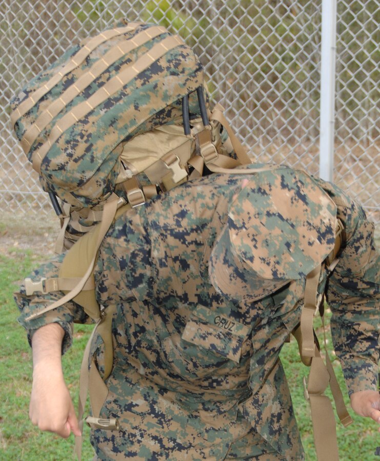 A Marine struggles to put his pack on following a rest stop along the 14-mile hike around Marine Corps Logistics Base Albany’s perimeter, Feb. 3.