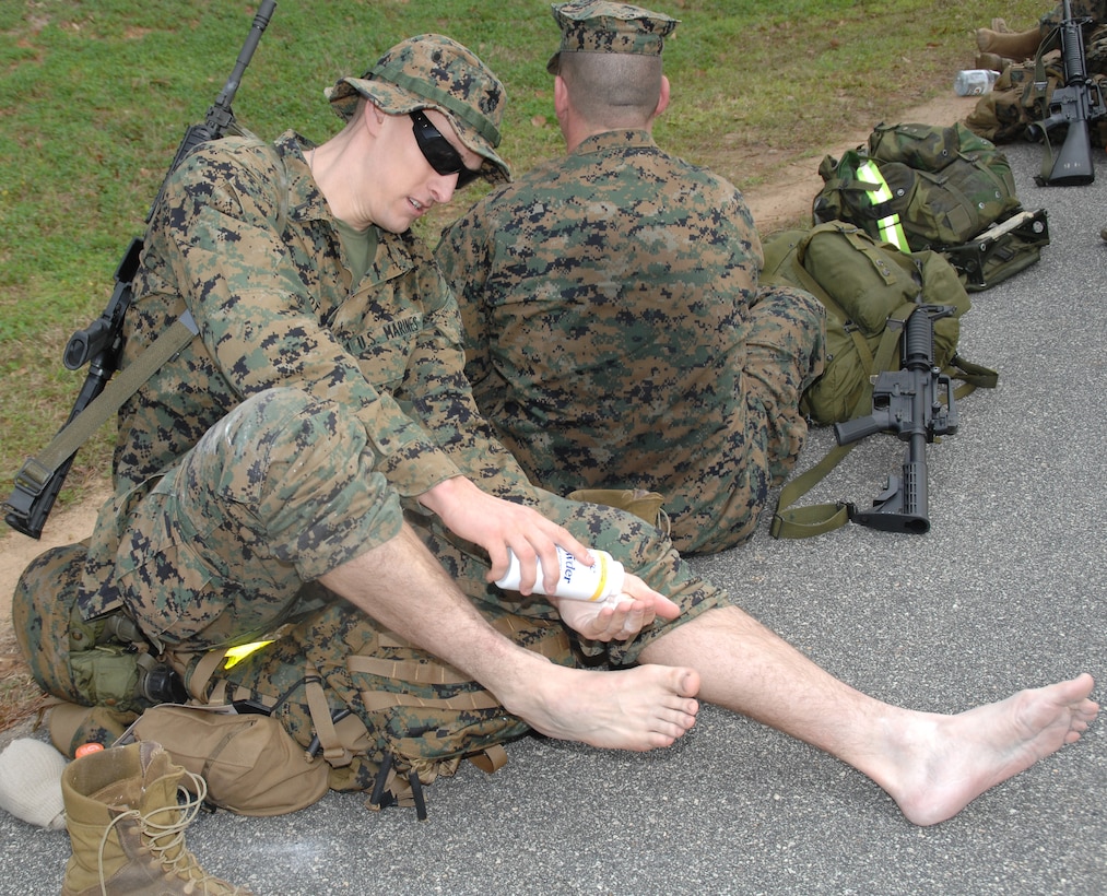 A Marine cares for his feet at a rest stop during a 14-mile hike around Marine Corps Logistics Base Albany’s perimeter, Feb. 3.
