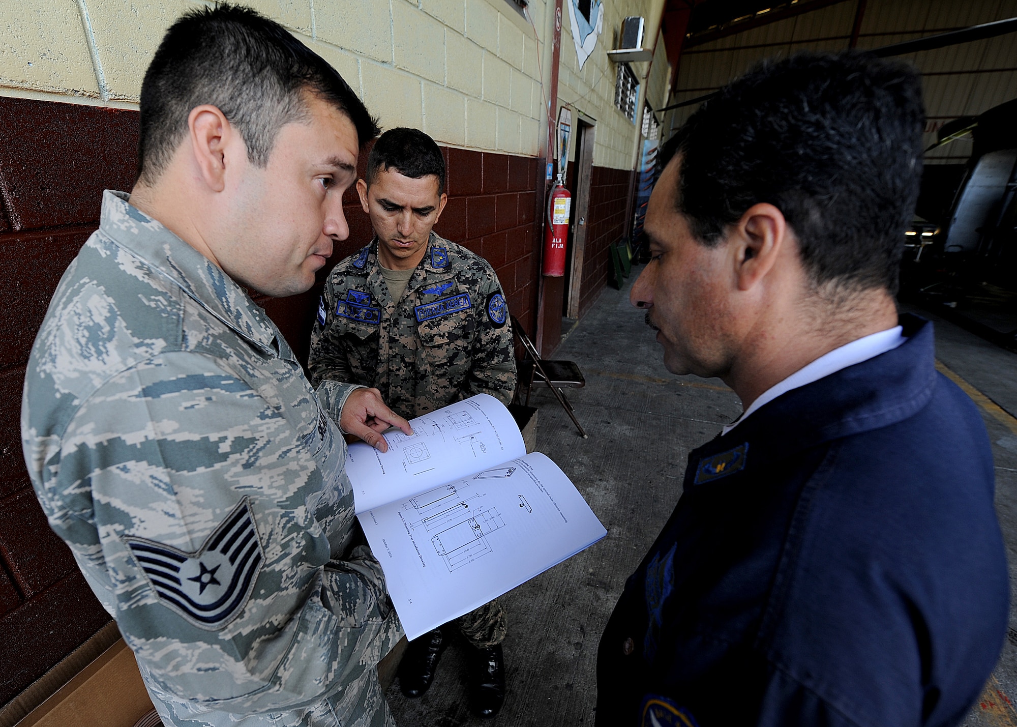 Technical Sgt. Ruben Sigala, Inter-American Air Forces Academy instructor, is showing members of the Honduran Air Force the dimension of the signal transmitter for the FAH helicopter, in Tegucigalpa, Honduras, Feb. 3.  (U.S. Air Force photo by Tech. Sgt. Lesley Waters)