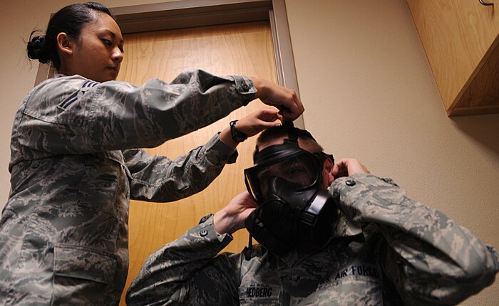 Senior Airman Icycrystal Sanjurjo,  9th Aerospace Medicine Squadron bioenvironmental engineer journeyman, conducts a gas mask fit test for  Airman 1st Class Nicholas Hedberg, a Beale Air Force member at the Bioenvironmental office at Beale Air Force Base, Calif., Feb. 1, 2012. Sanjurjo uses incense to ensure the gas mask has a tight seal. (U.S. Air Force photo by Airman 1st Class Brittany Paerschke-O'Brien/ Released)