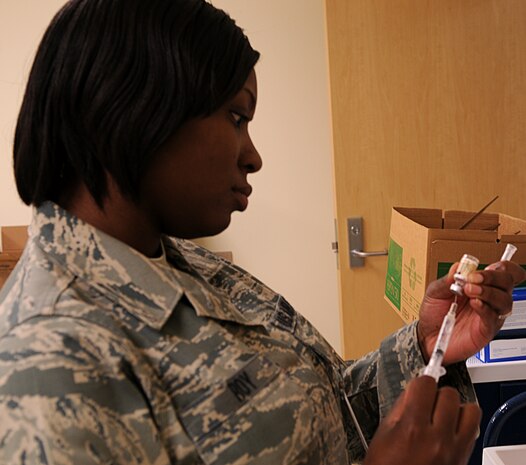 Staff Sergeant Labre Roy, 9th Aerospace Medicine Squadron medical technician, prepares to  administers a immunization shot to an Air Force member at Beale Air Force Base, Calif., Jan. 31, 2012. (U.S. Air Force photo by Airman 1st Class Brittany Paerschke-O'Brien/ Released)