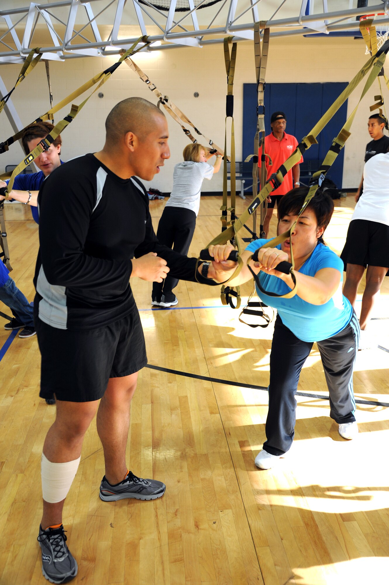 HOLLOMAN AIR FORCE BASE, N.M. -- U.S. Air Force 1st Lt. Jesse Murillo, 49th Force Support Squadron fitness director, instructs a participant during a TRX® class Jan. 27, at the Domenici Fitness and Sports Center. The TRX® is an industrial-grade harness of soft nylon webbing that allows users to safely suspend their bodies and employs the user's bodyweight in a variety of positions and at different resistances, which creates a total-body work out that delivers strength, flexibility and core stability all at once.