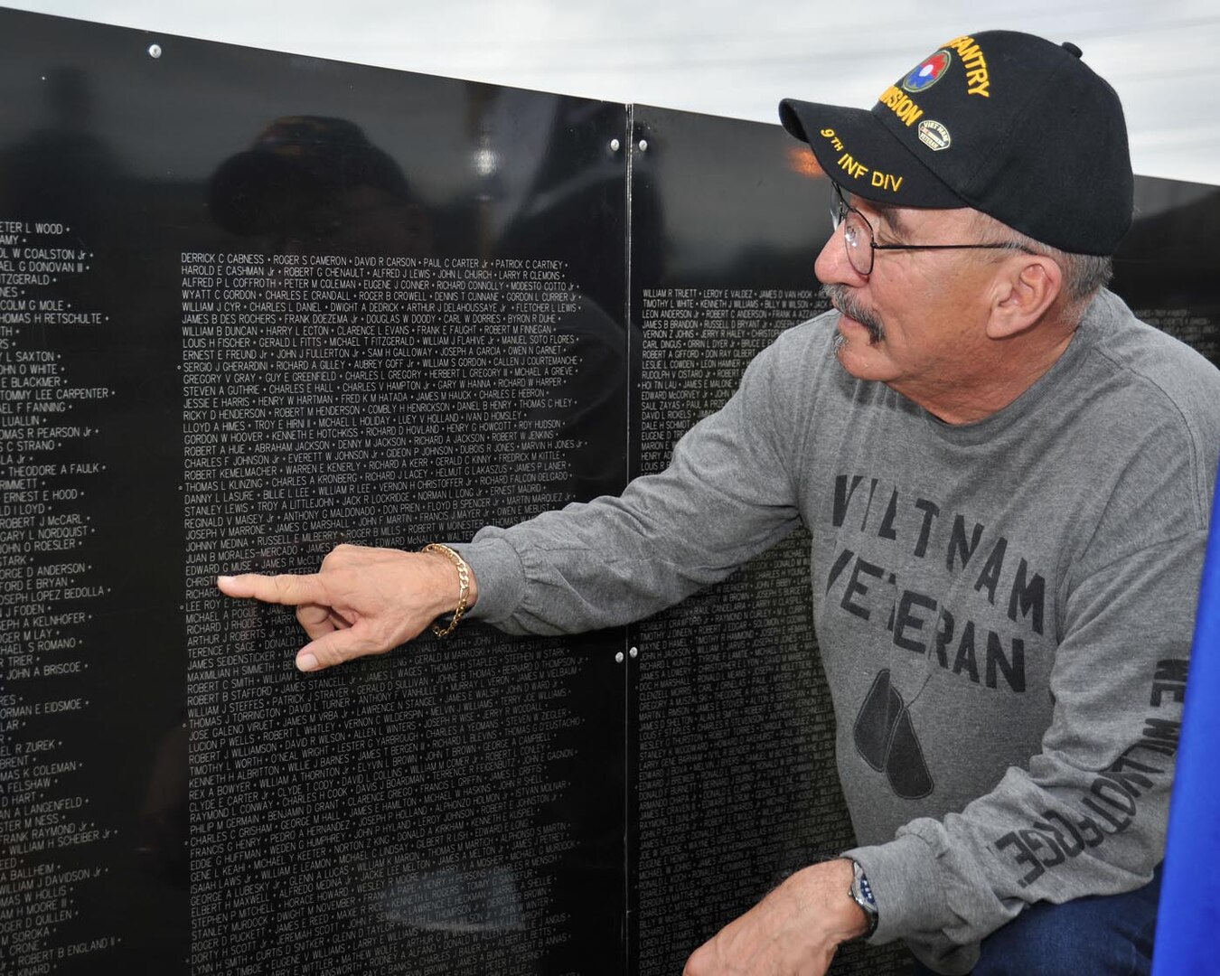 Ernest Ibarra of San Antonio finds the name of Airman 1st Class Edward G. Muse engraved upon the Vietnam Traveling Memorial Wall Tuesday at Joint Base San Antonio-Lackland. Muse was one of six security policemen killed in action during the Tet Offensive. Muse died Jan. 31, 1968 while defending Bien Hoa Air Base near Saigon. The base was assaulted by two North Vietnamese battalions. Although the base perimeter was breached in several places during the attack, primary defenders from the Air Force's 3rd Security Police Squadron were able to protect the heart of the base from ground attack until infantry reinforcements arrived at sun-up. Ibarra, a Purple Heart recipient, served in Vietnam as a U.S. Army specialist 4 in the infantry from 1968-1969. (U.S. Air Force photo/Alan Boedeker)