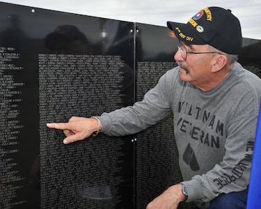 Ernest Ibarra of San Antonio finds the name of Airman 1st Class Edward G. Muse engraved upon the Vietnam Traveling Memorial Wall Tuesday at Joint Base San Antonio-Lackland. Muse was one of six security policemen killed in action during the Tet Offensive. Muse died Jan. 31, 1968 while defending Bien Hoa Air Base near Saigon. The base was assaulted by two North Vietnamese battalions. Although the base perimeter was breached in several places during the attack, primary defenders from the Air Force's 3rd Security Police Squadron were able to protect the heart of the base from ground attack until infantry reinforcements arrived at sun-up. Ibarra, a Purple Heart recipient, served in Vietnam as a U.S. Army specialist 4 in the infantry from 1968-1969. (U.S. Air Force photo/Alan Boedeker)