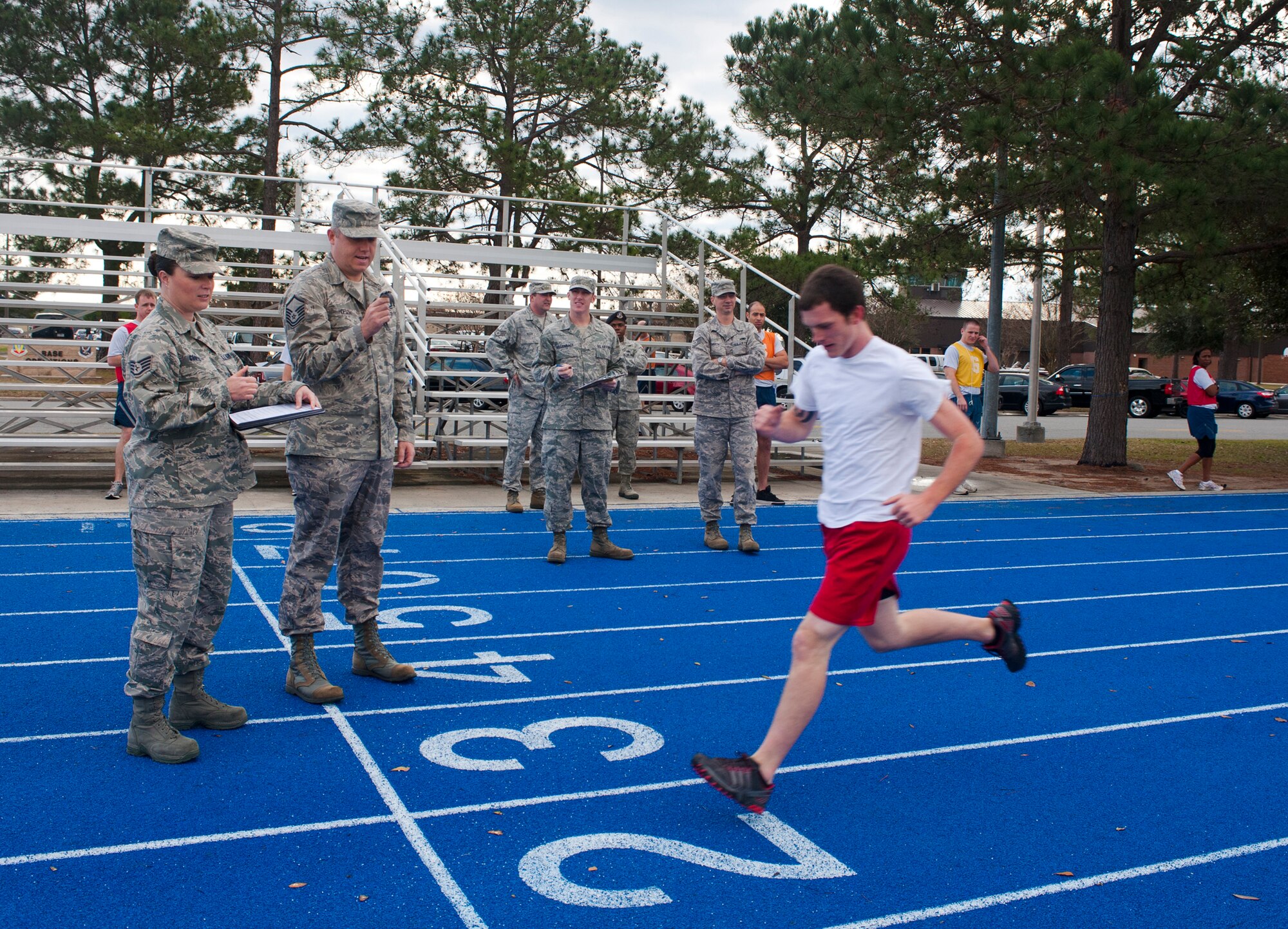 U.S. Air Force Master Sgt. David Hopson, 336th Recruiting Squadron flight chief, checks a stopwatch as a recruit crosses the finish line during a physical ability and stamina test (PAST) at Moody Air Force Base, Ga., Jan 27, 2012. Recruiters administer the PAST, which consists of a 1.5-mile run, pullups, two-minute timed pushups and two-minute timed sit-ups. (U.S. Air Force photo by Airman 1st Class Jarrod Grammel/Released)
