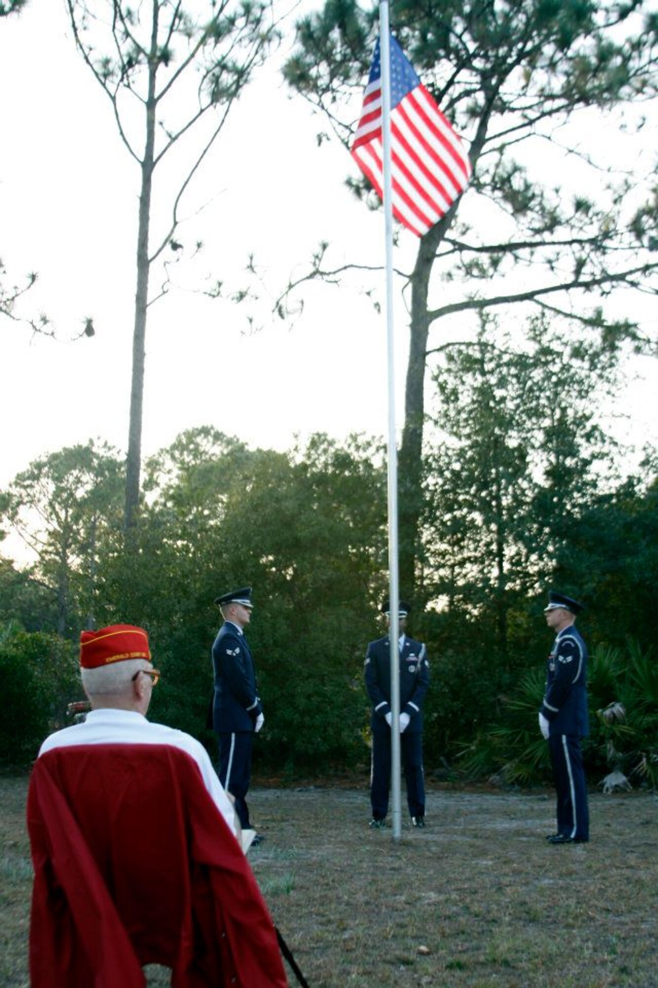 Retired U.S. Marine Corps Master Gunnery Sgt. Jay DeGraw, seated, watches as three Airmen from Hurlburt Field's Honor Guard prepare to conduct a retreat ceremony in Navarre, Fla., Jan. 31, 2012. Retreat ceremonies may signal the end of an official duty day on military installations as well as pay respect to the American flag. (U.S. Air Force photo by Senior Airman Steven Dieterle) (Released)