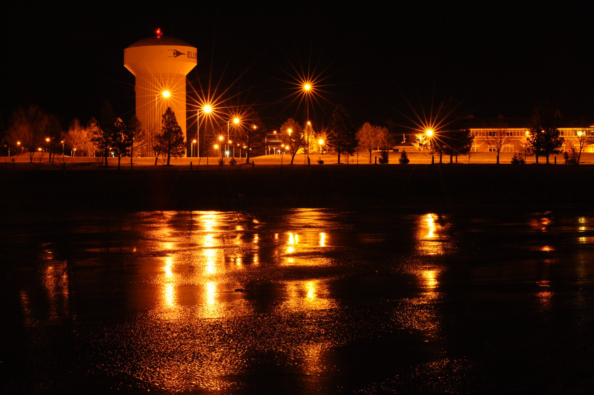 Street lights reflect off Heritage Lake on Ellsworth Air Force Base, S.D., Jan. 28, 2012. Ellsworth has been experiencing an unusually warm winter season with an average temperature of 41 degrees and 1.6 inches of snow, compared to the 32 degrees and 5.2 inches of snow for the month of January 2011. Airmen should be advised that going out on the ice for any reason is prohibited. (U.S. Air Force photo by Airman 1st Class Zachary Hada/Released)