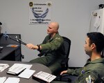 Maj. Stephen Manley (left), 559th Flying Training Squadron instructor pilot, demonstrates flight procedures to 1st Lt. William Dana, 558th FTS instructor candidate.  (U.S. Air Force photo/Don Lindsey)