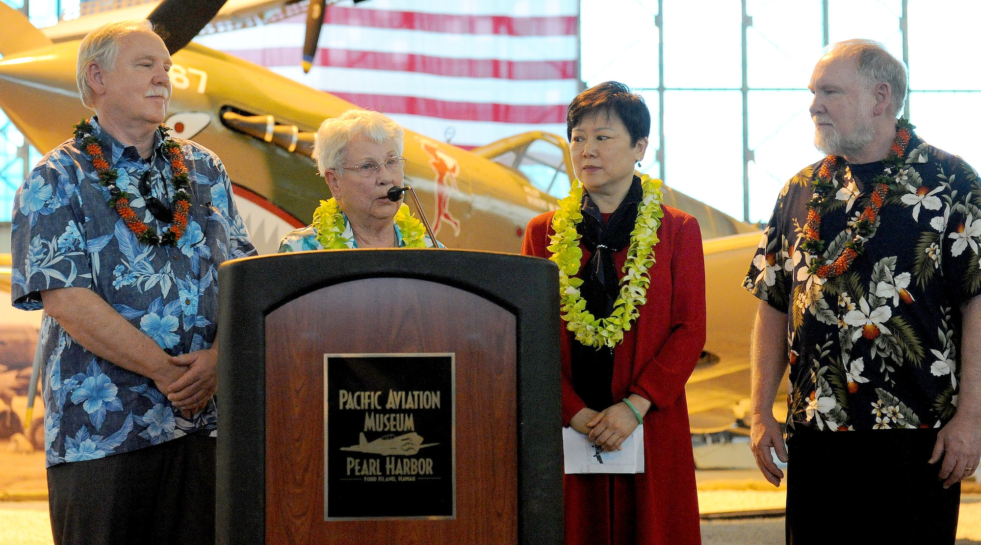 FORD ISLAND, Hawaii--Mrs. Elinor Beneda, spouse of the late Lt. Glen Beneda, a ‘Flying Tigers’ fighter pilot with the 14th Air Force, speaks to an audience during an event celebrating the legacy of the U.S.-China friendship, held at the Pacific Aviation Museum, Ford Island, Hawaii, Jan. 30, 2012. During the event, the President of the Chinese People’s Association for Friendship with Foreign Countries, Madame Li Xiaolin, presented her film documentary, Touching the Tigers, which tells the story of Beneda, who was shot down and wounded while defending China from Japanese forces during World War II. The documentary also details how Chinese farmers and soldiers helped Beneda escape capture before he was returned to a U.S. air base for medical care. (U.S. Air Force photo/Tech. Sgt. Jerome S. Tayborn/Released)