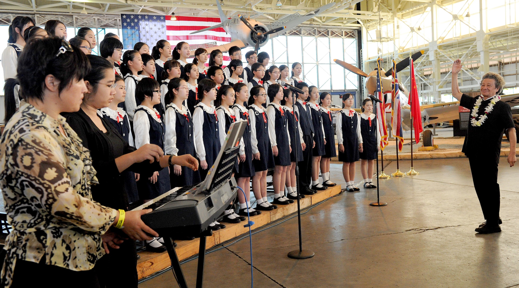 FORD ISLAND, Hawaii--The China Children’s Choir of Beijing sings the national anthems of the USA and China at an event celebrating the legacy of the U.S.-China friendship, held at the Pacific Aviation Museum, Ford Island, Hawaii, Jan. 30, 2012. During the event, the President of the Chinese People’s Association for Friendship with Foreign Countries, Madame Li Xiaolin, presented her film documentary, Touching the Tigers, which tells the story of Lt. Glen Beneda, a ‘Flying Tigers’ fighter pilot with the 14th Air Force, who was shot down and wounded while defending China from Japanese forces during World War II. The documentary also details how Chinese farmers and soldiers helped Beneda escape capture before he was returned to a U.S. air base for medical care. (U.S. Air Force photo/Tech. Sgt. Jerome S. Tayborn/Released)
