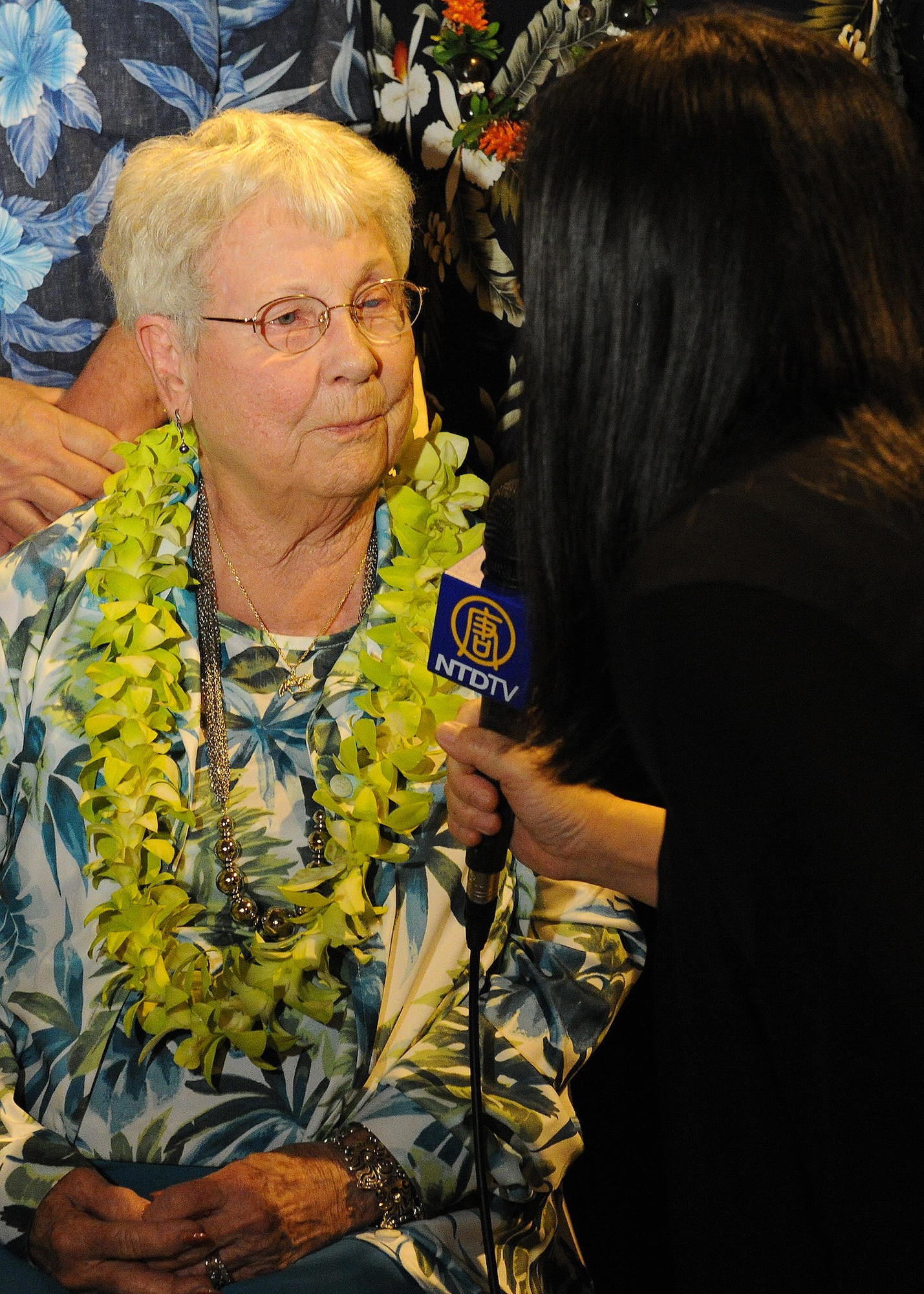 FORD ISLAND, Hawaii--Mrs. Elinor Beneda, spouse of the late Lt. Glen Beneda, a ‘Flying Tigers’ fighter pilot with the 14th Air Force, is interviewed by a New Tang Dynasty Television reporter, at an event celebrating the legacy of the U.S.-China friendship, held at the Pacific Aviation Museum, Ford Island, Hawaii, Jan. 30, 2012. During the event, the President of the Chinese People’s Association for Friendship with Foreign Countries, Madame Li Xiaolin, presented her film documentary, Touching the Tigers, which tells the story of Beneda, who was shot down and wounded while defending China from Japanese forces during World War II. The documentary also details how Chinese farmers and soldiers helped Beneda escape capture before he was returned to a U.S. air base for medical care. (U.S. Air Force photo/Tech. Sgt. Jerome S. Tayborn/Released)