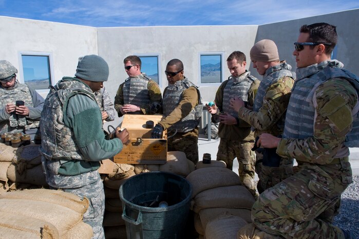 U.S. Air Force pararescuemen, 58th Rescue Squadron, and combat arms instructors unload fragmentation grenades during grenade training Jan. 27, 2012, on the Nevada Test and Training Range.  Pararescuemen are trained to provide emergency medical treatment in adverse terrain and conditions, in combat or peacetime.  (U.S. Air Force photo by Staff Sgt. William P. Coleman)

