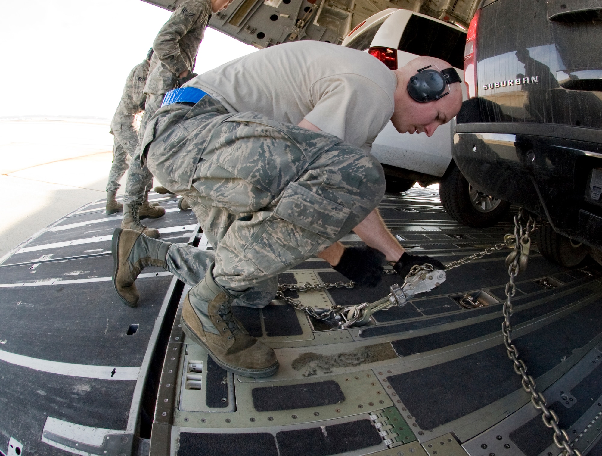 Staff Sgt. Nicholas Worrell, 89th Aerial Port Squadron aircraft services specialist, tightens down an MB-1 chain device to secure vehicles inside a            C-17 aircraft during a presidential-level mission here Jan. 25. (Photo/Bobby Jones)